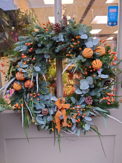 Orange & Berry Wreath - A handcrafted Christmas wreath filled with fresh seasonal foliage, berries, pinecones and natural festive accents to brighten any front door.